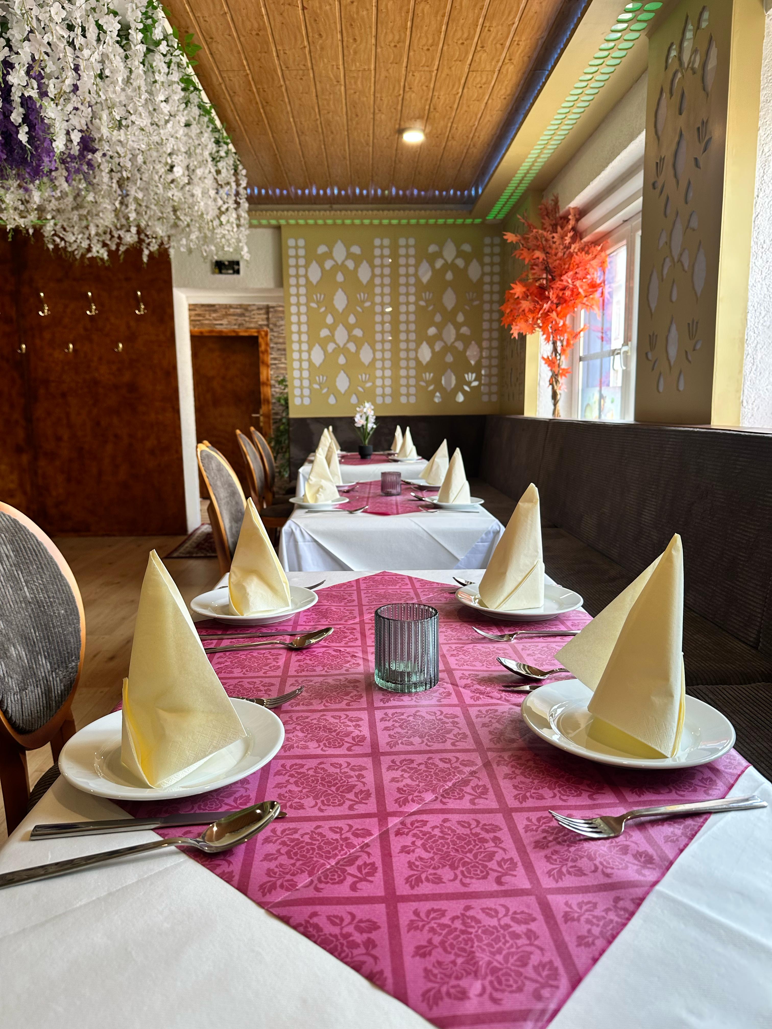 Gemütliches Restaurant-Interieur mit Tischen und indischer Dekoration